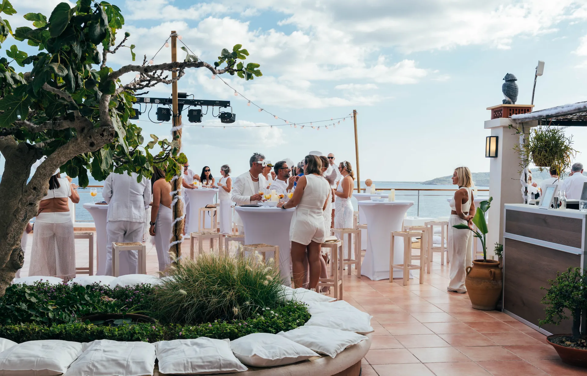 Guests at an intimate private celebration on an Ibiza villa terrace at sunset
